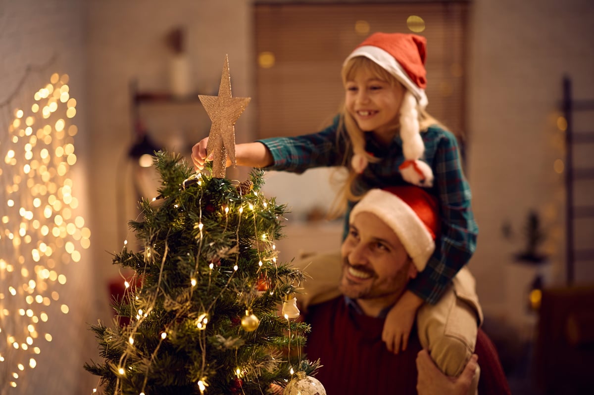 Father and daughter decorating Christmas tree