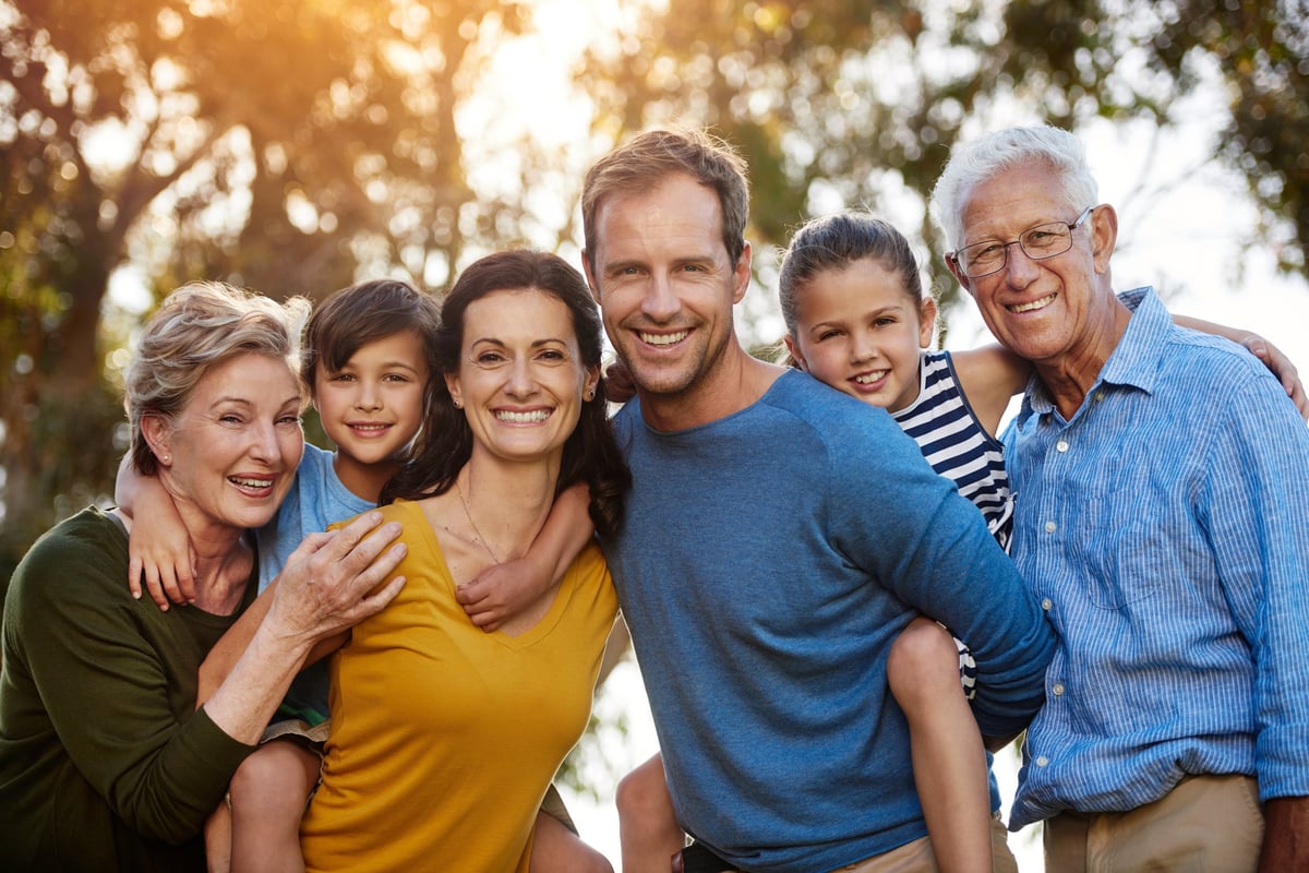 Happy family of four posing together outdoors